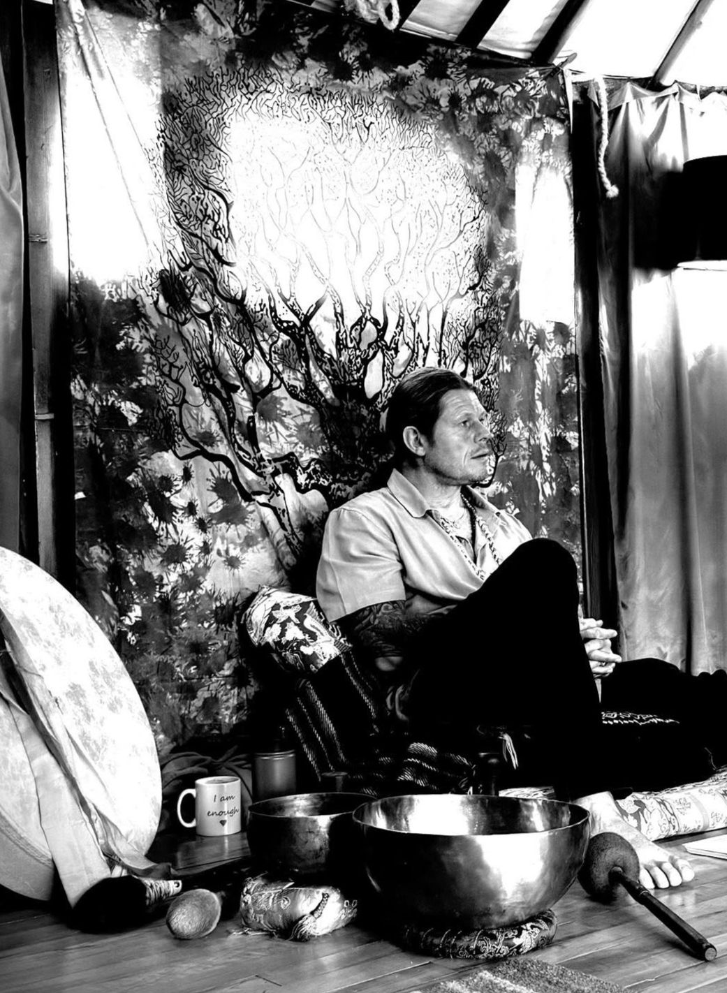 A sound practitioner seated beside singing bowls